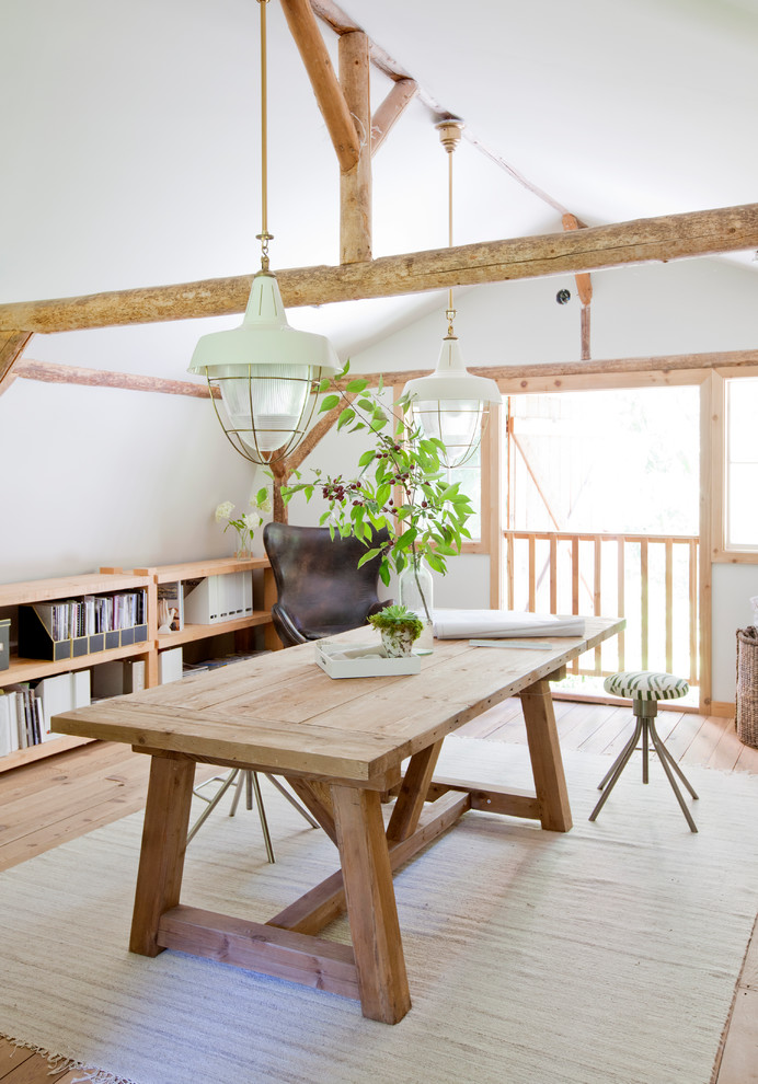 Idéer för att renovera ett lantligt hemmabibliotek, med vita väggar, ett fristående skrivbord, ljust trägolv och beiget golv