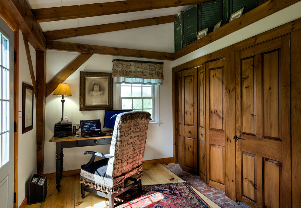 Modelo de despacho campestre sin chimenea con paredes blancas, suelo de madera clara y escritorio independiente