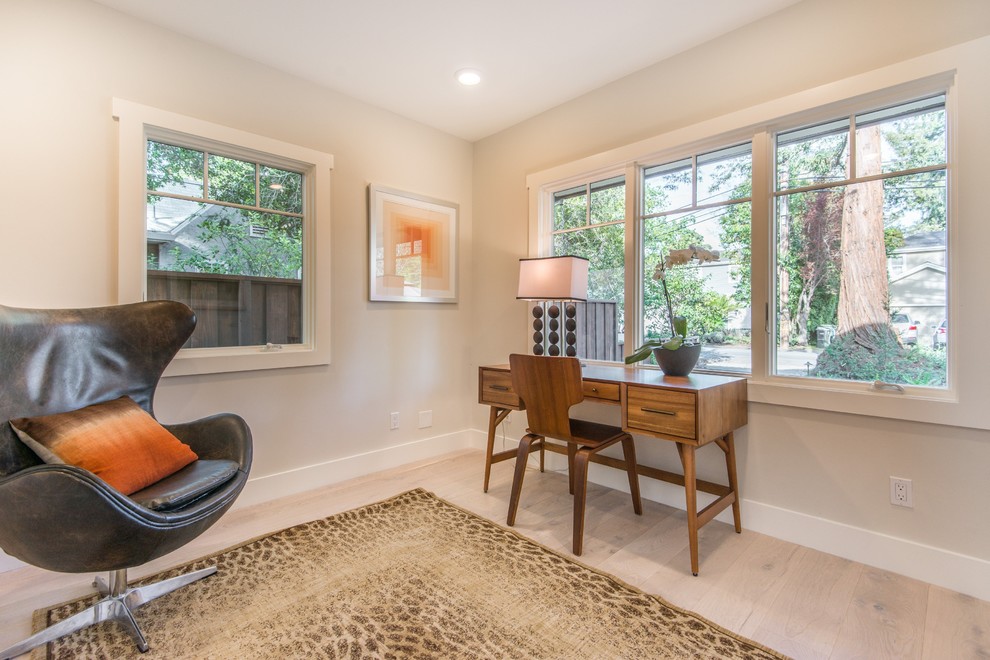 This is an example of a contemporary home office in San Francisco with beige walls, light hardwood flooring, no fireplace and a freestanding desk.