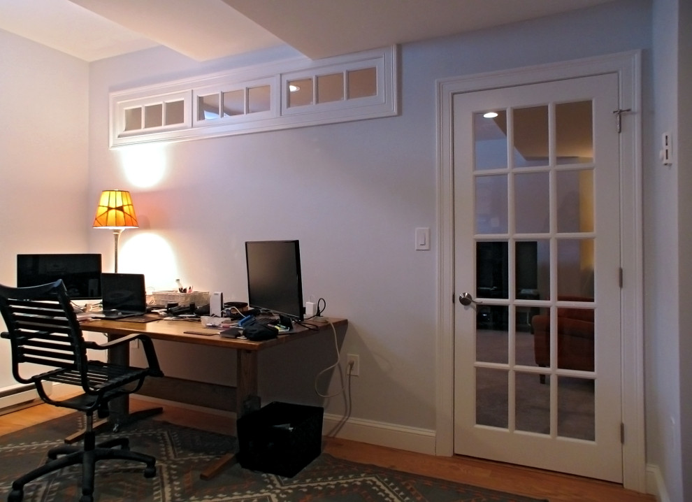 Cette image montre un très grand bureau design avec un mur gris, parquet clair et aucune cheminée.