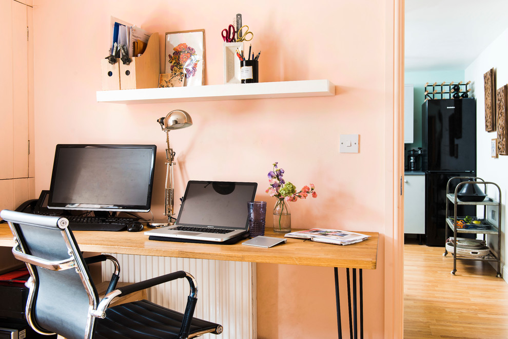 Bohemian home office in London with pink walls and a freestanding desk.
