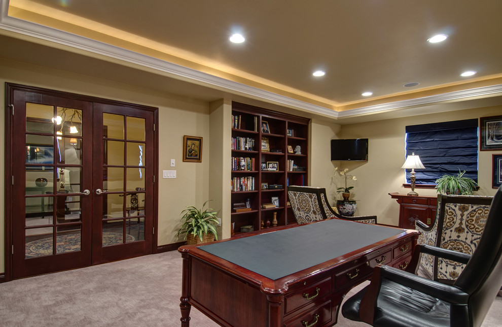 Ejemplo de despacho clásico grande sin chimenea con paredes beige, moqueta, escritorio independiente y suelo beige
