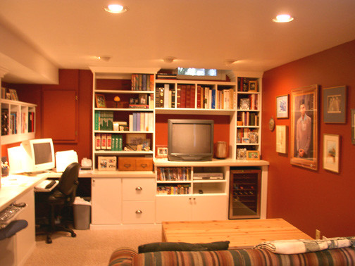 Inredning av ett klassiskt stort arbetsrum, med röda väggar, heltäckningsmatta, ett inbyggt skrivbord och beiget golv
