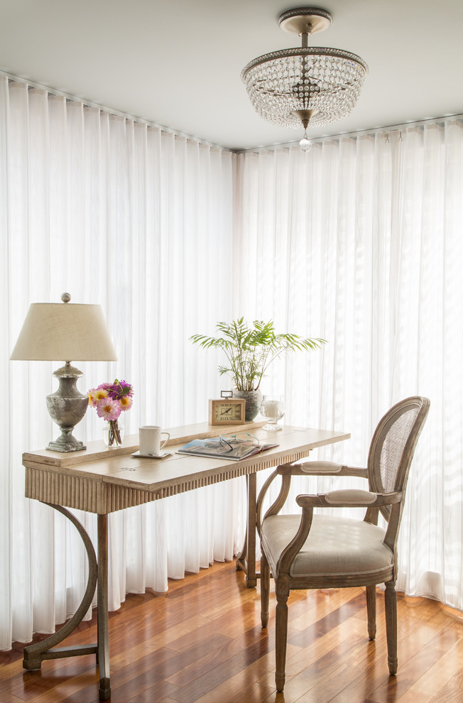 Foto de despacho tradicional de tamaño medio sin chimenea con escritorio independiente, paredes blancas y suelo de madera en tonos medios