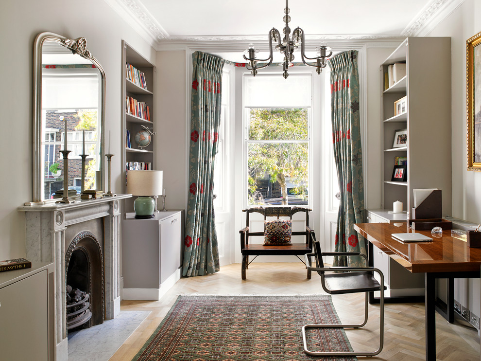 ロンドンにあるヴィクトリアン調のおしゃれな書斎 (グレーの壁、無垢フローリング、標準型暖炉、自立型机) の写真