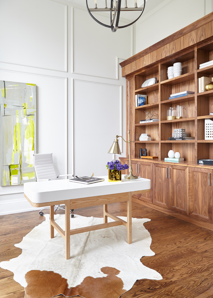 Imagen de despacho clásico renovado grande sin chimenea con paredes blancas, suelo de madera en tonos medios, escritorio independiente y suelo marrón