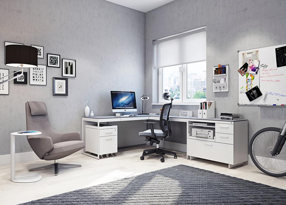 Idee per un grande studio minimal con pareti grigie, parquet chiaro e scrivania autoportante