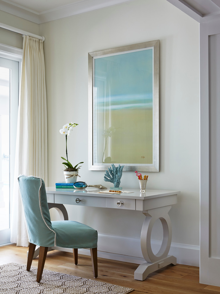Ejemplo de despacho marinero con suelo de madera en tonos medios, escritorio independiente y paredes beige