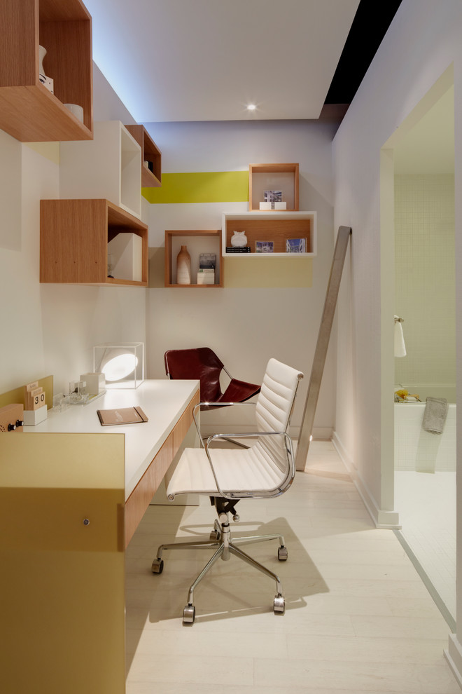 Modelo de despacho contemporáneo pequeño con paredes blancas, suelo de madera clara y escritorio independiente