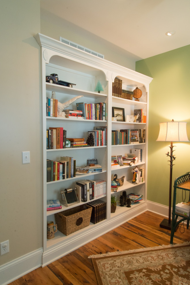 Foto di uno studio stile marino di medie dimensioni con libreria, pareti verdi, pavimento in legno massello medio, scrivania autoportante e pavimento marrone