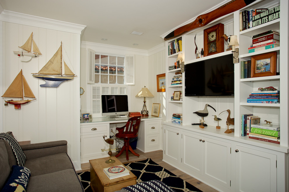 Foto på ett maritimt arbetsrum, med vita väggar, ljust trägolv och ett inbyggt skrivbord