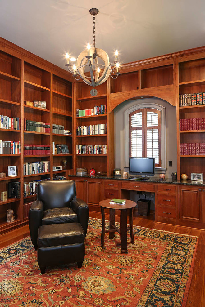 Großes Klassisches Arbeitszimmer mit Arbeitsplatz, braunem Holzboden und Einbau-Schreibtisch in New Orleans