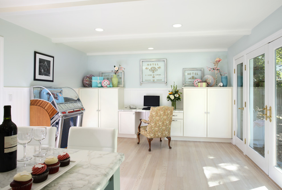Foto de despacho romántico de tamaño medio con paredes azules, suelo de madera clara y escritorio empotrado