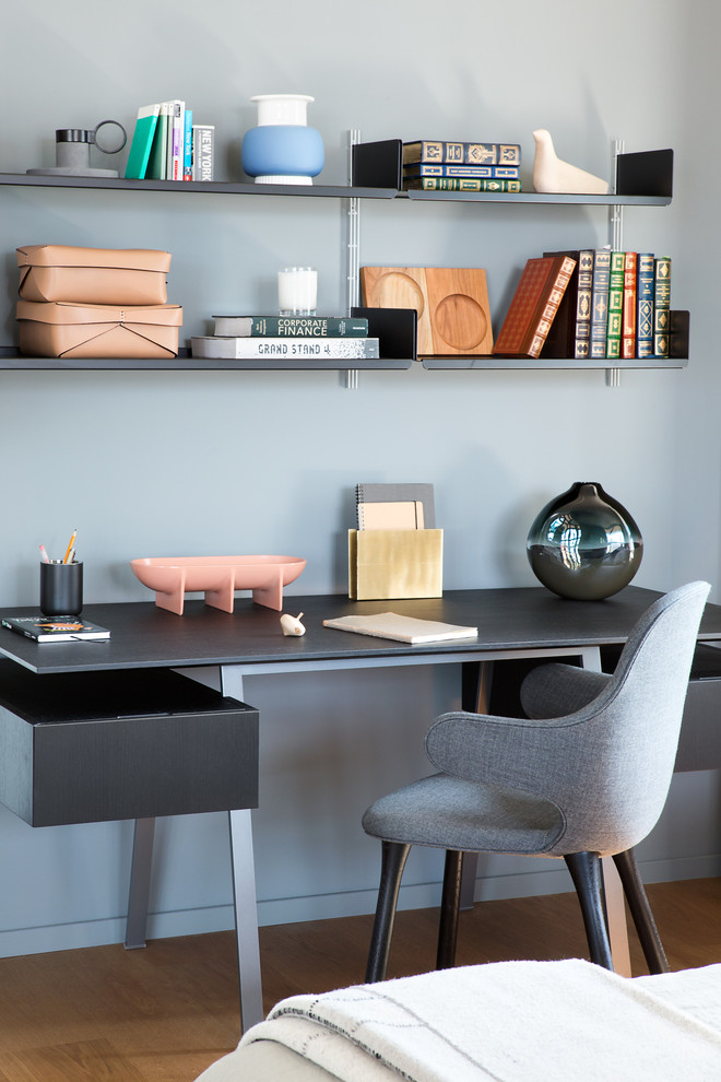 Exemple d'un bureau tendance de taille moyenne avec un mur gris, aucune cheminée, un bureau indépendant et un sol en bois brun.