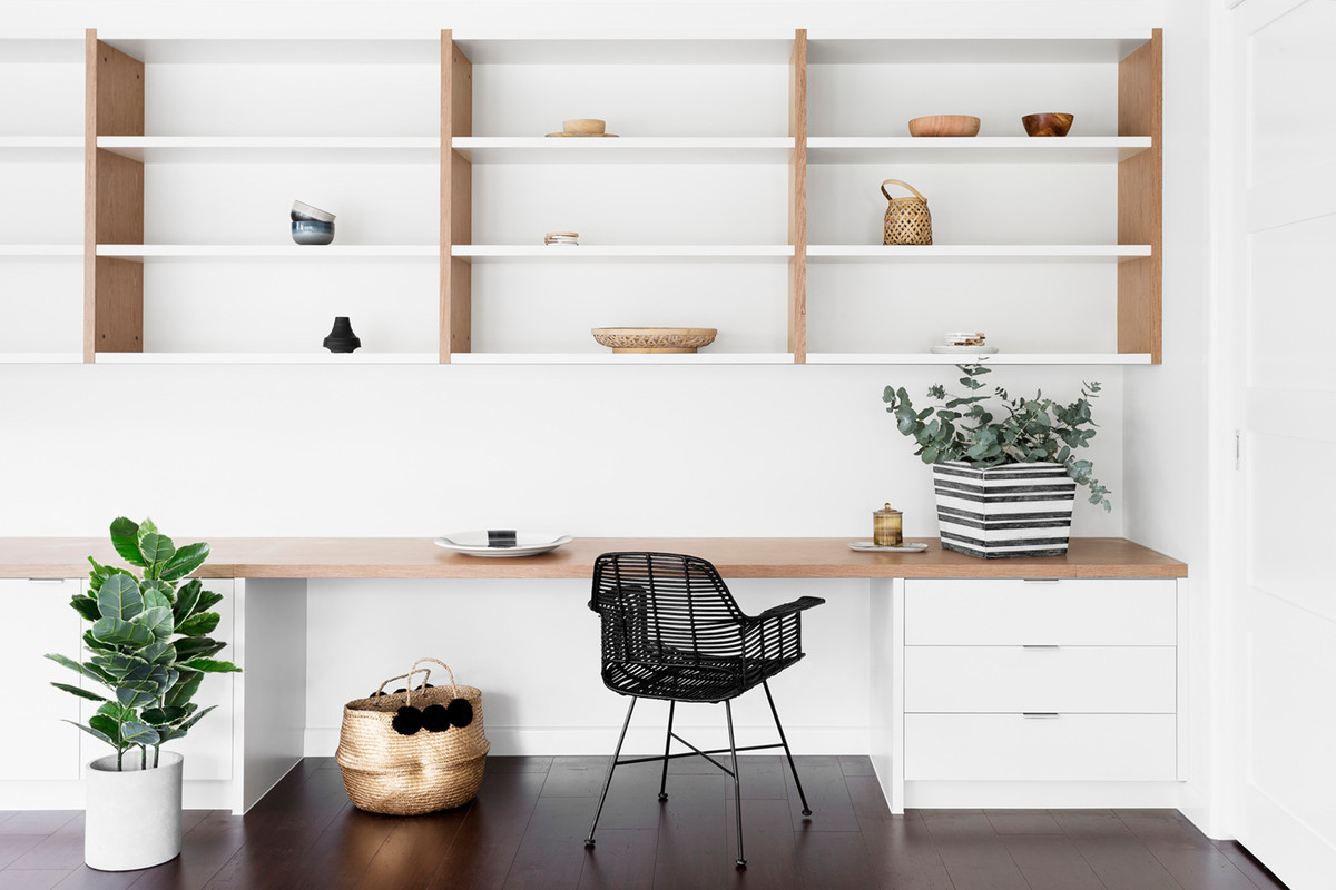Idéer för att renovera ett minimalistiskt hemmabibliotek, med vita väggar, mörkt trägolv och ett inbyggt skrivbord
