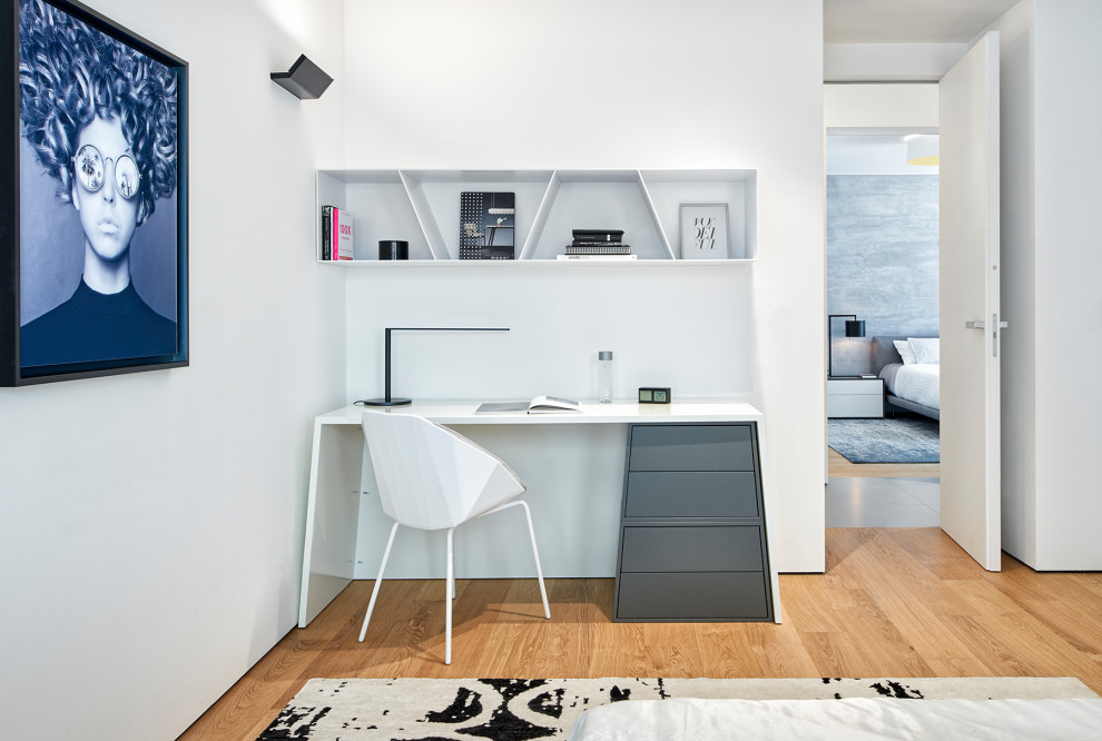 Immagine di un piccolo studio design con pareti bianche, pavimento in legno massello medio, pavimento marrone e scrivania autoportante