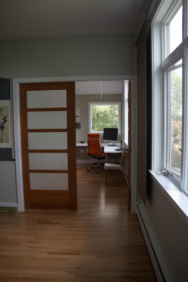 Mittelgroßes Modernes Arbeitszimmer mit Studio, grüner Wandfarbe, braunem Holzboden und freistehendem Schreibtisch in Boston