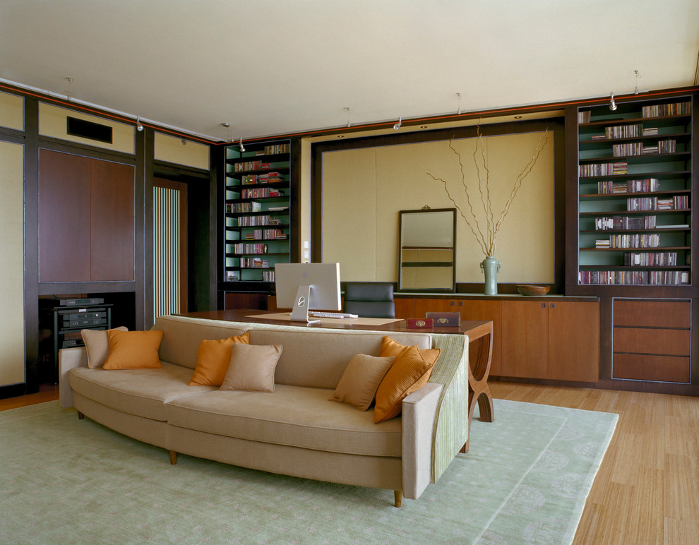 Modernes Arbeitszimmer mit beiger Wandfarbe, braunem Holzboden und freistehendem Schreibtisch in New York