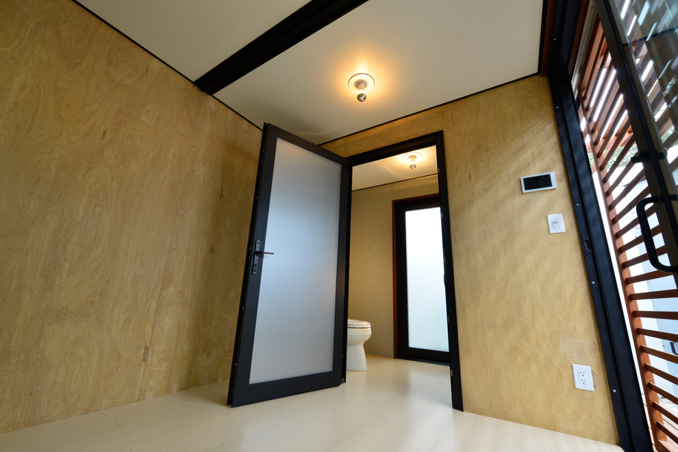 This is an example of a small modern home studio in Los Angeles with light hardwood flooring.