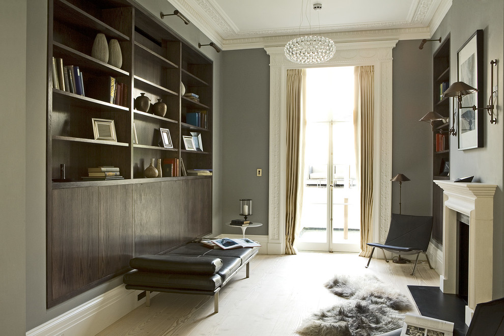 Cette photo montre un bureau romantique de taille moyenne avec un mur gris, parquet clair, une cheminée standard, un manteau de cheminée en pierre et un bureau intégré.