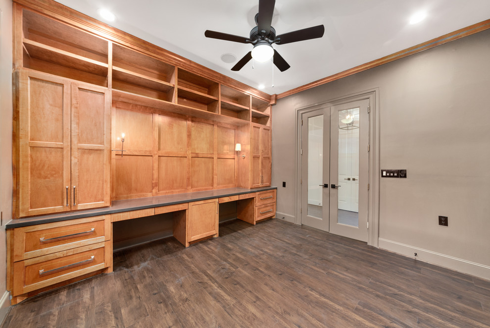 Imagen de despacho tradicional renovado de tamaño medio sin chimenea con paredes beige, suelo laminado, escritorio empotrado y suelo marrón