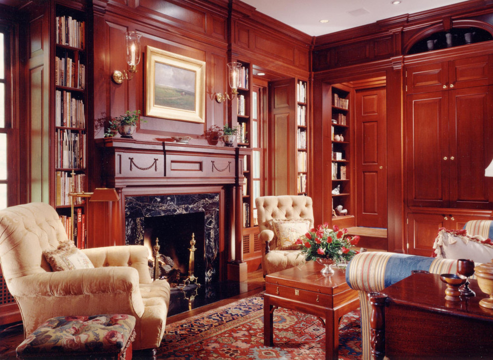 Klassisk inredning av ett mellanstort arbetsrum, med ett bibliotek, mörkt trägolv, en standard öppen spis, en spiselkrans i sten, bruna väggar och brunt golv