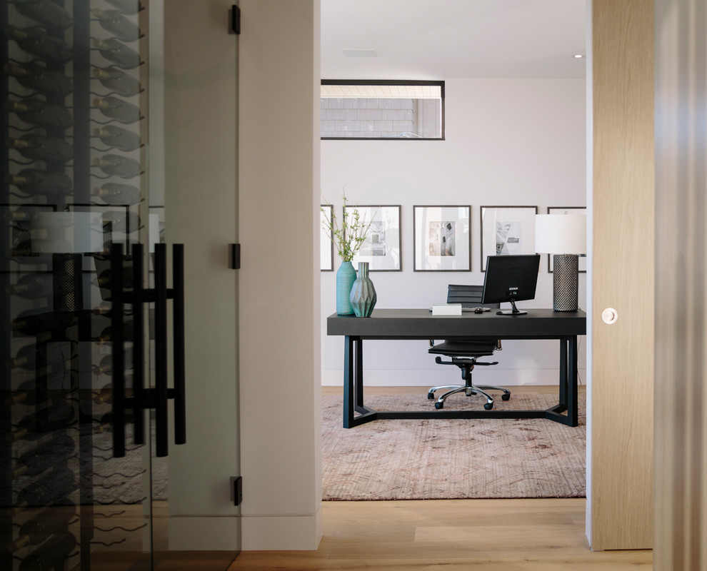 Imagen de despacho contemporáneo grande con paredes blancas, suelo de madera en tonos medios y escritorio independiente