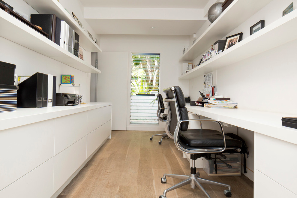 Inspiration for a mid-sized contemporary built-in desk light wood floor and beige floor home office remodel in Sydney with white walls