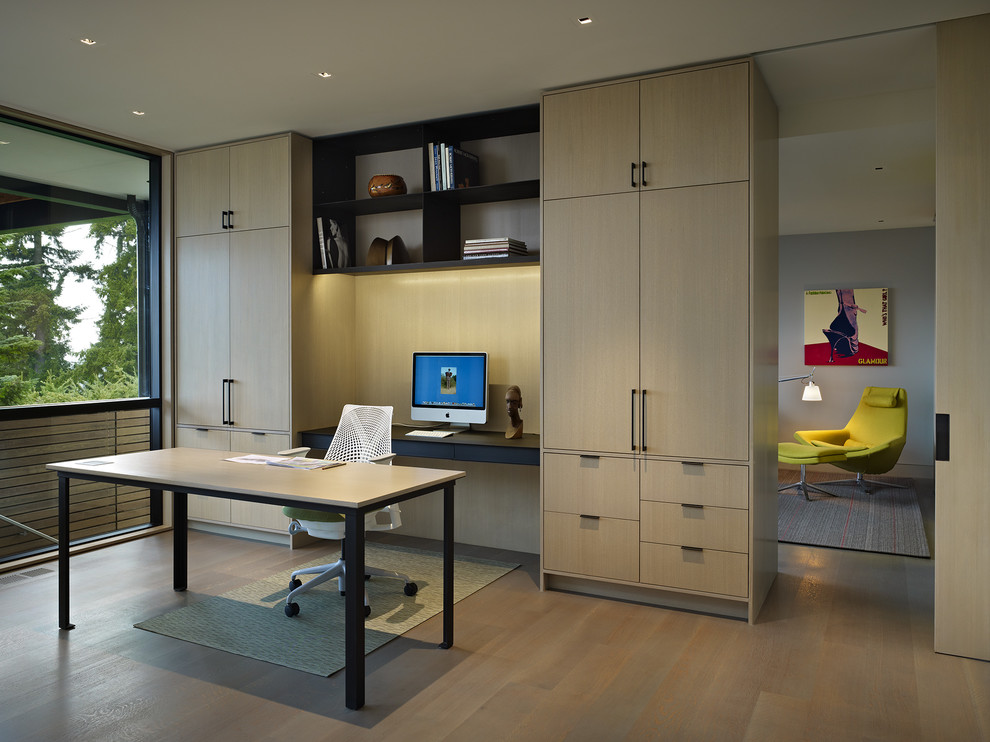 Inspiration for a contemporary home office in Seattle with light hardwood flooring, a freestanding desk and beige floors.