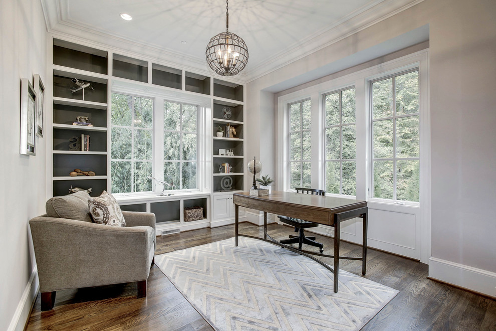 Imagen de despacho de estilo americano de tamaño medio con paredes blancas, suelo de madera en tonos medios y escritorio independiente