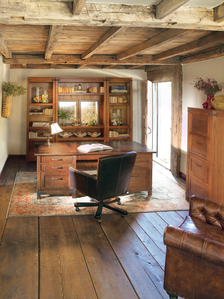 Diseño de despacho tradicional con paredes blancas, suelo de madera oscura, escritorio independiente y suelo marrón