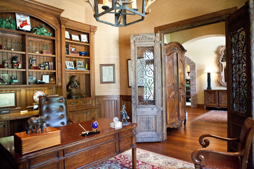 Inspiration för ett stort vintage hemmabibliotek, med beige väggar, mellanmörkt trägolv och ett fristående skrivbord