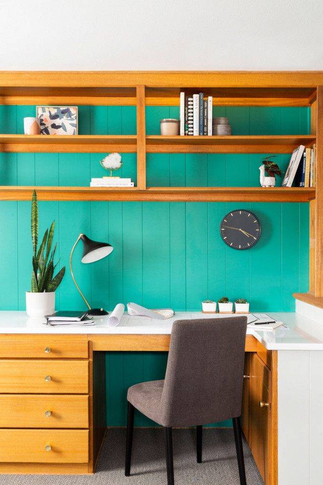На фото: домашняя библиотека среднего размера в морском стиле с зелеными стенами, ковровым покрытием, встроенным рабочим столом и серым полом без камина