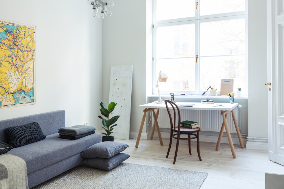 Inspiration for a large contemporary study in Berlin with grey walls, light hardwood flooring, no fireplace and a freestanding desk.