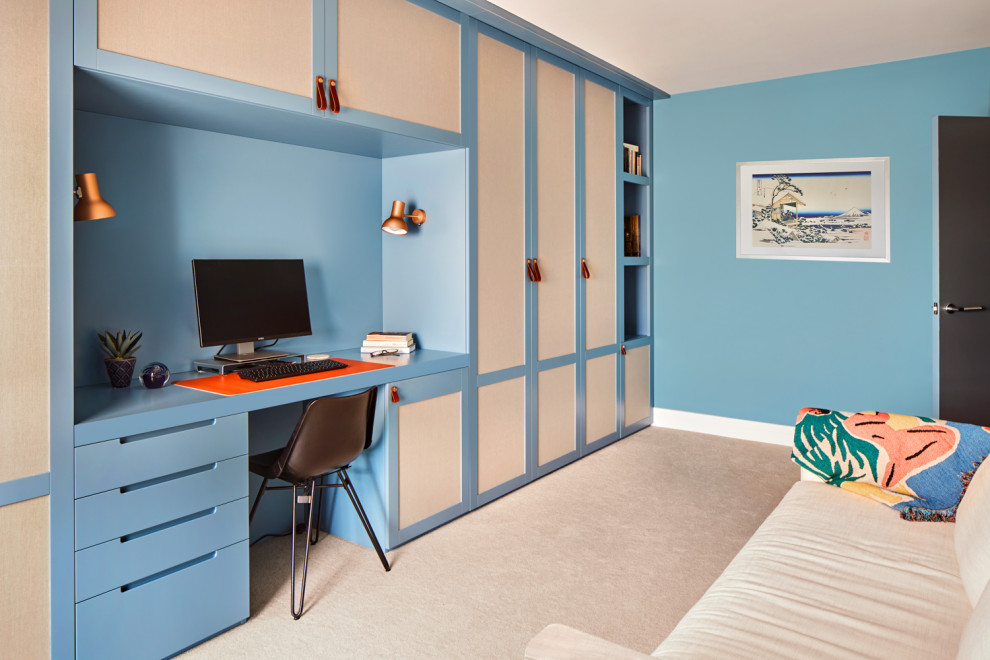 Design ideas for a medium sized traditional home office in London with blue walls, carpet, a built-in desk and beige floors.