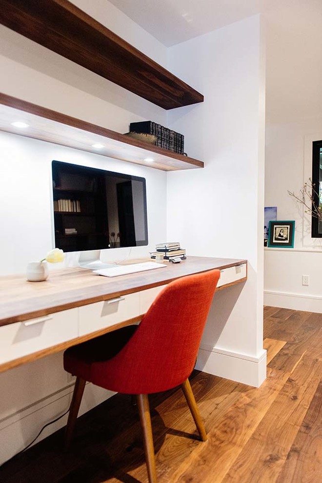 Immagine di un ufficio minimal con pareti bianche, parquet scuro, scrivania incassata e pavimento marrone
