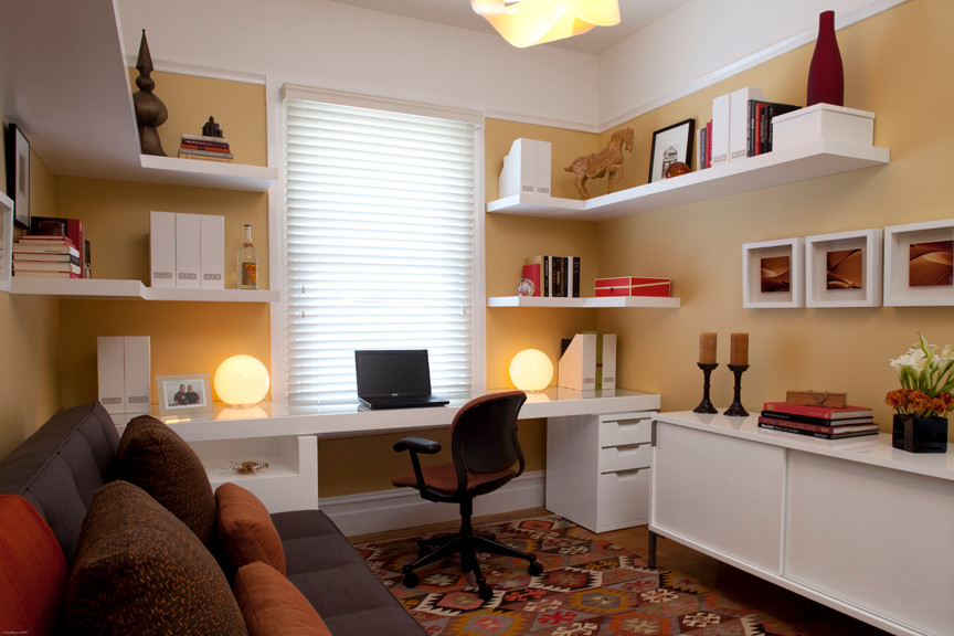 Esempio di un piccolo studio contemporaneo con pavimento in legno massello medio, pavimento marrone, scrivania incassata e pareti arancioni
