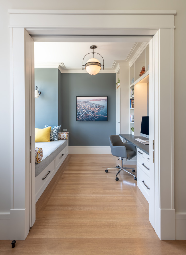 Study room - transitional built-in desk medium tone wood floor and brown floor study room idea in San Francisco with gray walls