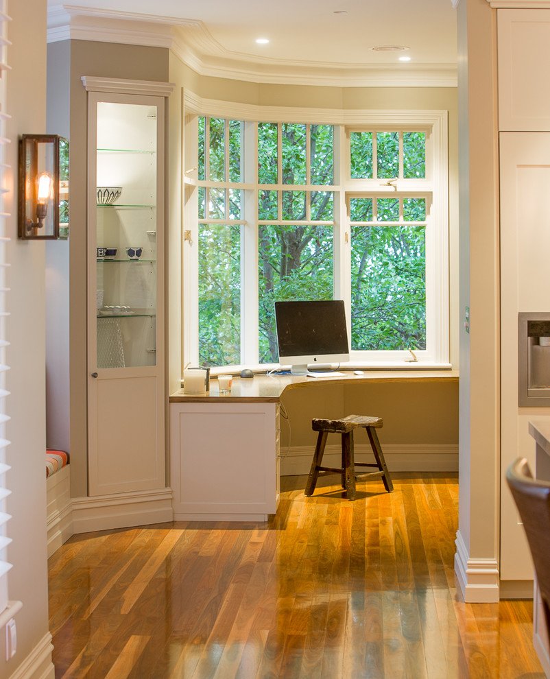 Mittelgroßes Klassisches Arbeitszimmer mit Arbeitsplatz, Einbau-Schreibtisch, beiger Wandfarbe und braunem Holzboden in Melbourne