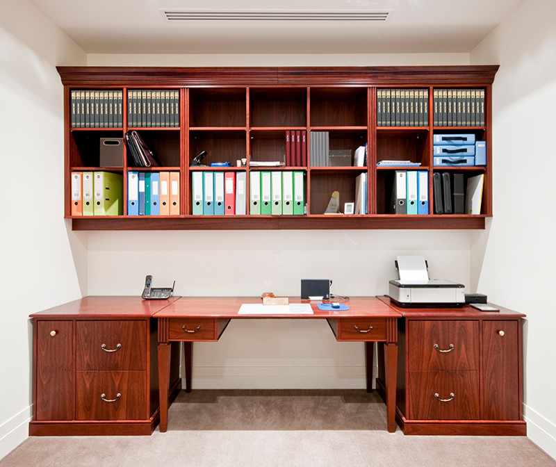 Modern inredning av ett mellanstort arbetsrum, med vita väggar, heltäckningsmatta och ett fristående skrivbord