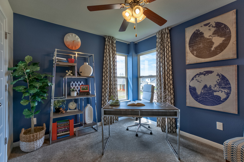 На фото: рабочее место в стиле неоклассика (современная классика) с синими стенами, ковровым покрытием и отдельно стоящим рабочим столом без камина