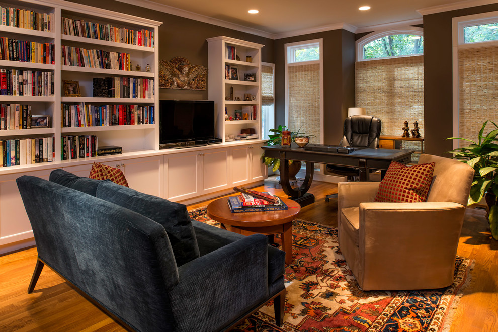Design ideas for a classic study in DC Metro with a freestanding desk, brown walls and light hardwood flooring.