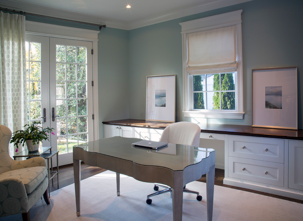 Ejemplo de despacho clásico renovado de tamaño medio sin chimenea con paredes azules, suelo de madera oscura y escritorio independiente
