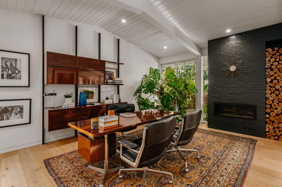 Inspiration for a medium sized midcentury home office in Los Angeles with light hardwood flooring, a ribbon fireplace, a brick fireplace surround and a freestanding desk.