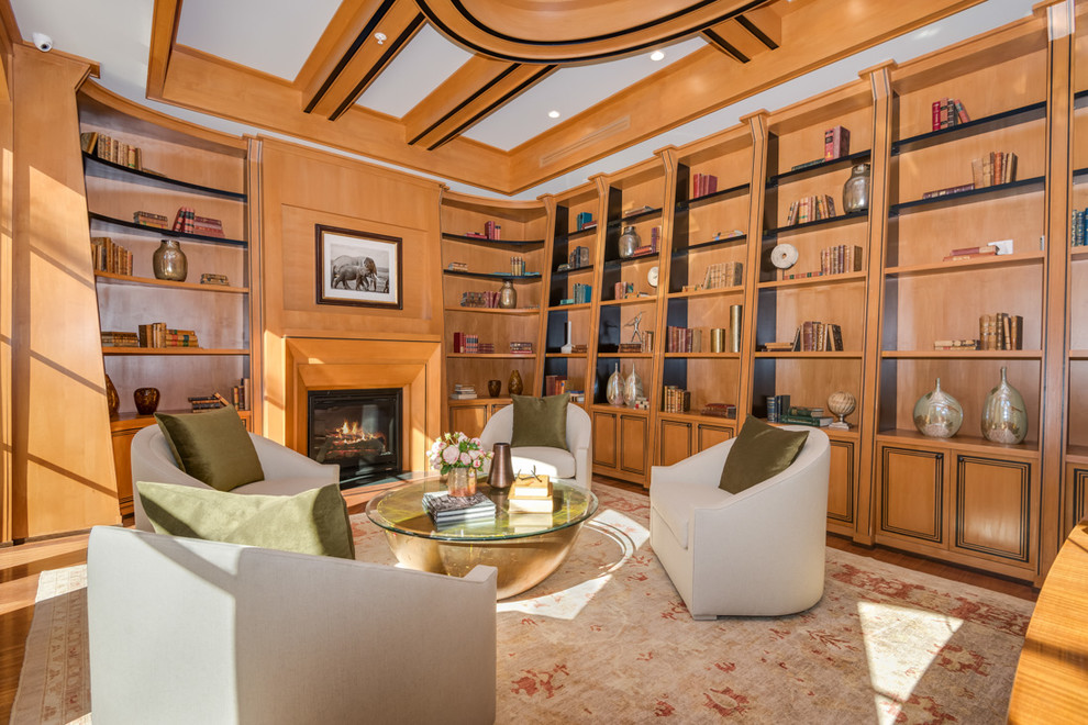 ロサンゼルスにあるコンテンポラリースタイルのおしゃれなホームオフィス・書斎 (無垢フローリング、標準型暖炉、木材の暖炉まわり、ライブラリー) の写真