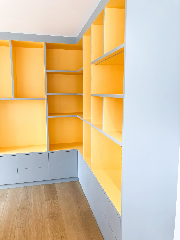 Cette image montre un bureau minimaliste de type studio avec un mur blanc, parquet clair, un bureau intégré et un sol beige.