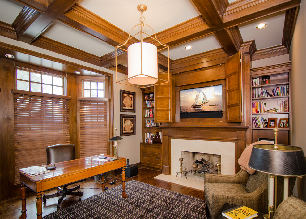 Cette image montre un bureau traditionnel de taille moyenne avec un mur beige, parquet foncé, une cheminée standard, un manteau de cheminée en carrelage, un bureau indépendant et un sol marron.