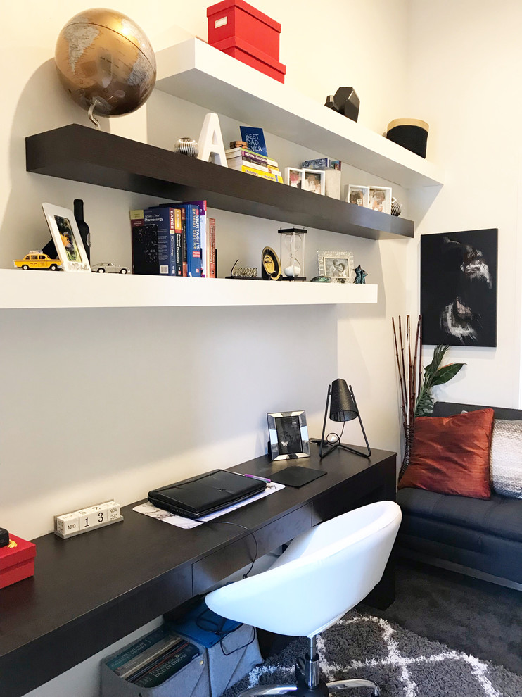 Modelo de despacho contemporáneo pequeño con paredes blancas, moqueta, escritorio empotrado y suelo marrón
