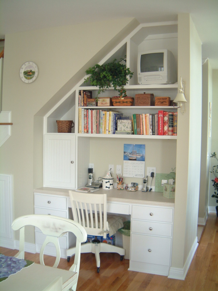 Diseño de despacho costero pequeño con paredes beige, suelo de madera en tonos medios y escritorio empotrado