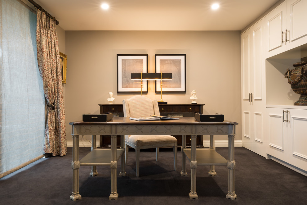 Imagen de despacho bohemio grande con paredes beige, moqueta y escritorio independiente